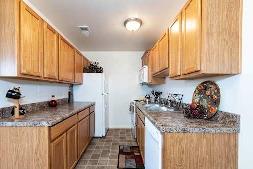 A kitchen with wooden cabinets and a granite countertop.