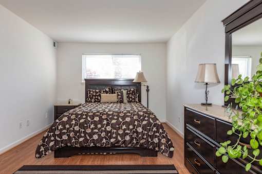 A bedroom with a bed, nightstand, and lamp.