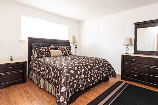 A bedroom with a large bed and a mirror on the wall.