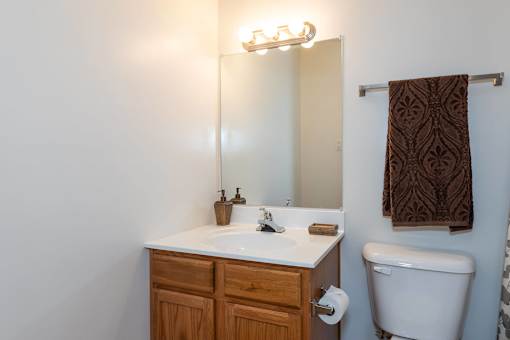 A white sink with a brown towel hanging on the wall.