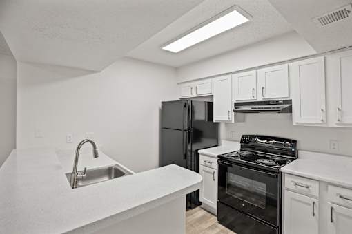 A kitchen with white cabinets and appliances.