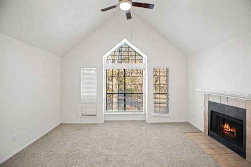 A room with a fireplace and a ceiling fan.