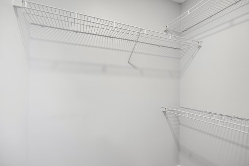 a walk in closet with white walls and a wire shelf at Midtown Crossing in Raleigh, North Carolina 27609
