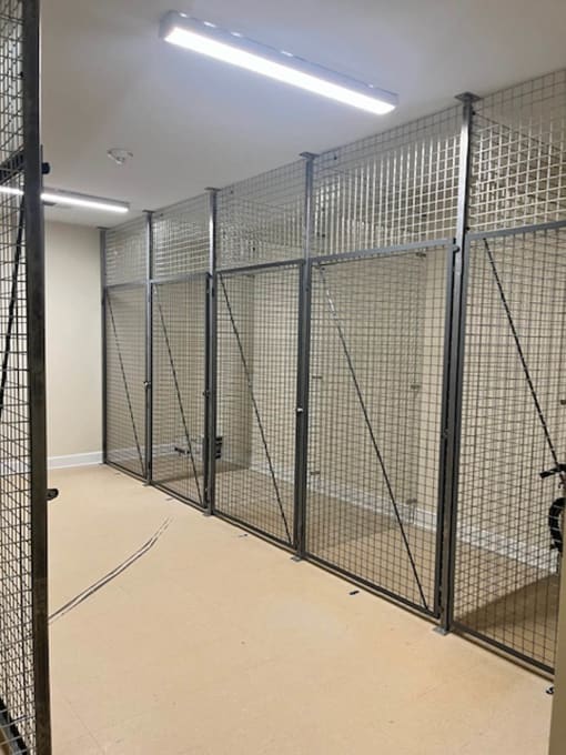the inside of a jail cell with welded metal doors