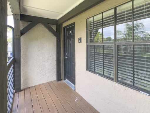a front porch with a door and windows