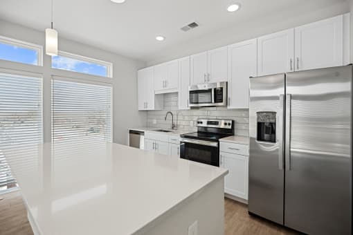 Experience culinary bliss in our newly custom-built kitchens featuring expansive quartz counter island and space filled with natural lighting at Centro at Pine Nash, Wilson, NC, 27893