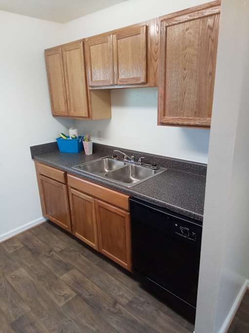 A kitchen with wooden cabinets and a black countertop.