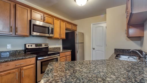 a kitchen with granite counter tops and wooden cabinets