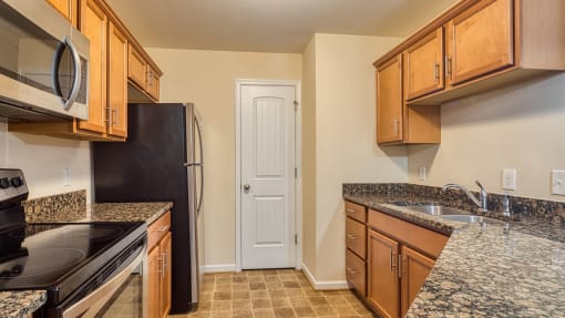 a kitchen with granite counter tops and wooden cabinets