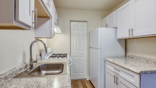 a kitchen with white cabinets and a sink and a refrigerator at Gates of West Bay in Norfolk, VA 