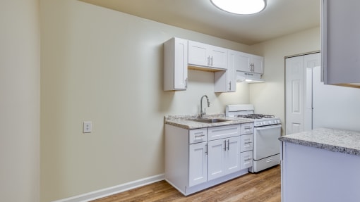 an empty kitchen with white cabinets and a white stove and refrigerator at Gates of West Bay in Norfolk, Virginia