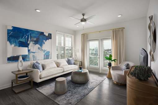 A living room with a white couch, a blue abstract painting, a wooden coffee table, and a rug.