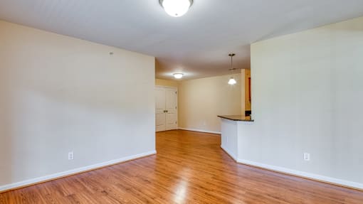 an empty living room with white walls and wood floors