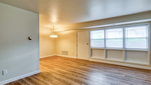 an empty living room with wood floors and windows at Gates of West Bay in Norfolk, Virginia 23503