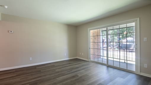 an empty living room with a door to a patio