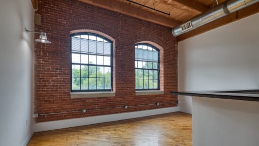 an empty room with two large windows at The Hudson, Richmond, VA, 23224