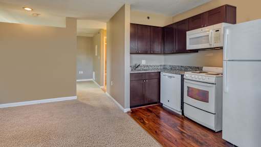 A kitchen with white appliances and brown cabinets.