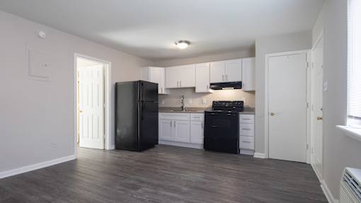 A kitchen with black appliances and white cabinets.