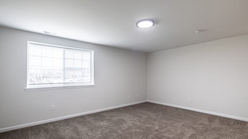 an empty room with carpet and a window