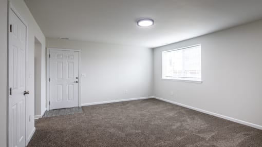 an empty room with carpet and a window