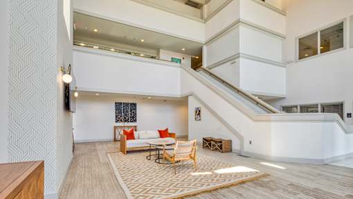 A living room with a white couch and a rug.