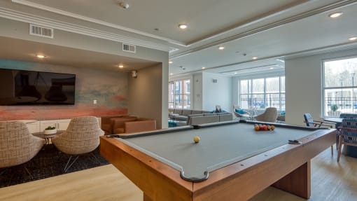 a community room with a pool table and a tv at The Bella at Westchester, Midlothian, VA