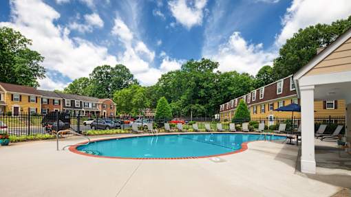 A swimming pool surrounded by a fence and trees.
