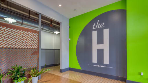 a large green and grey logo on a grey wall in an office at The Hudson, Richmond