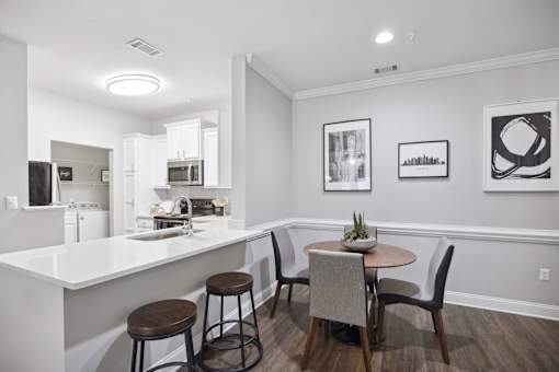 A kitchen with a bar and chairs.