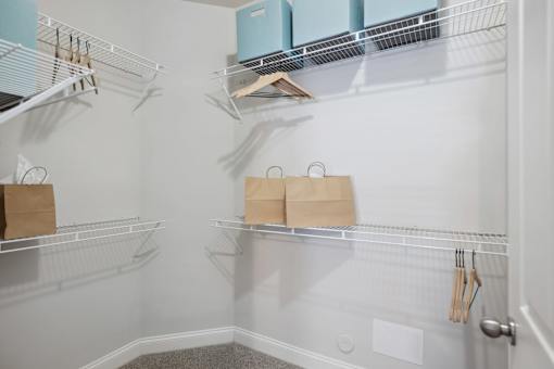 A kitchen pantry with a white wall and a door.