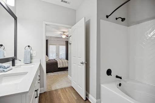 A white bathroom with a white tub and sink.