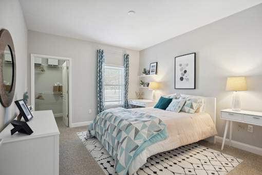 A bedroom with a bed, a dresser, and a mirror.