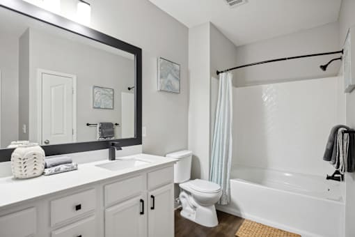 A white bathroom with a sink, toilet, and bathtub.