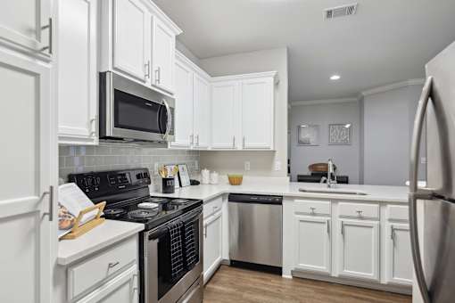 A kitchen with white cabinets and appliances.