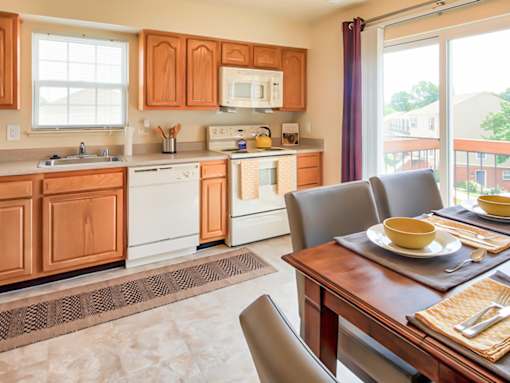 A kitchen with wooden cabinets and a dining table with two chairs.