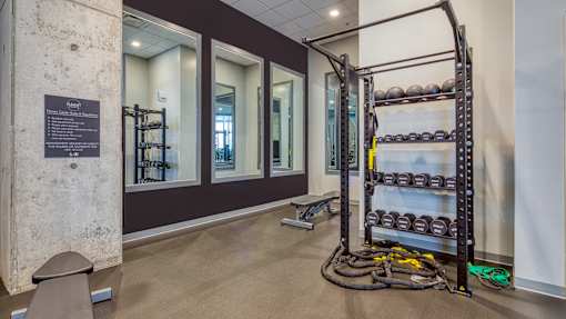 A gym with a rack of dumbbells and a bench.