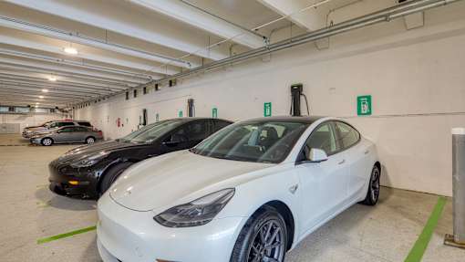 A white car is parked in a parking garage.