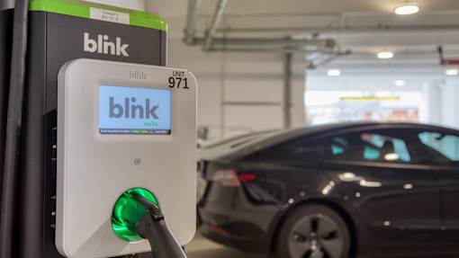 A Blink charging station is plugged into a car.