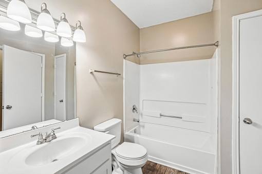 A white bathroom with a toilet, sink, and bathtub.