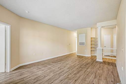 A room with wooden flooring and white walls.