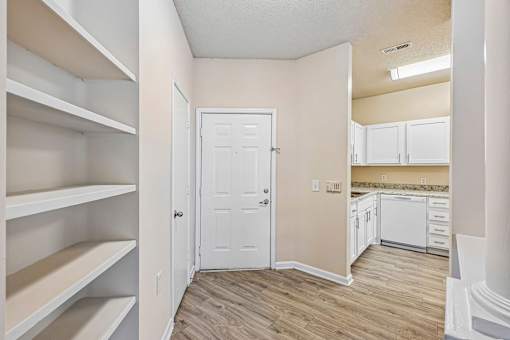 A white door is in a room with a wood floor.