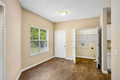 A room with a window and a door leading to another room.