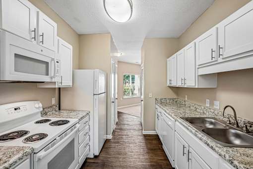 A kitchen with white appliances and cabinets.