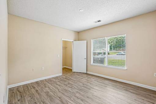 A room with a white door and a window with blinds.