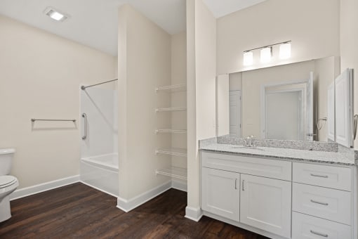 a bathroom with a large mirror and a toilet and a shower