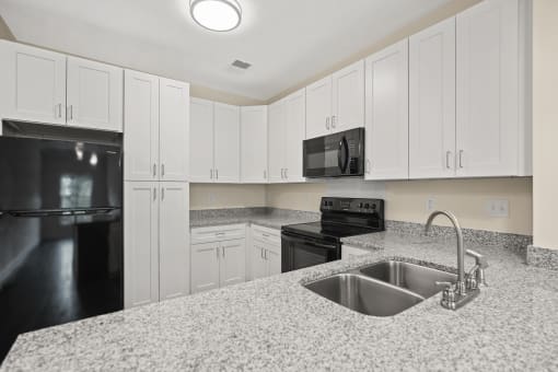 a kitchen with granite counter tops and black appliances