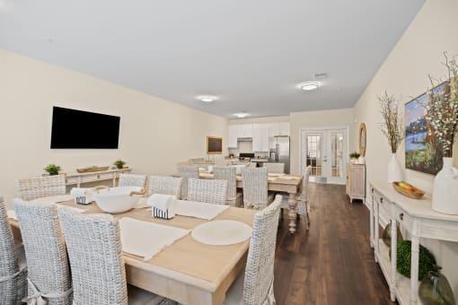 a dining room with tables and chairs and a living room with a tv