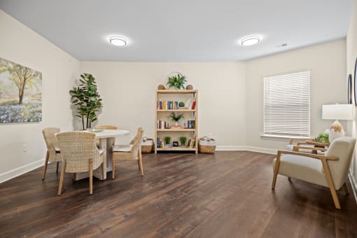 a living room with a table and chairs and a window