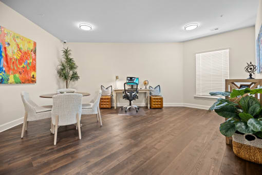 a living room with white chairs and a table with a computer