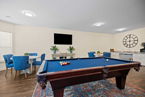 a games room with a pool table and a tv